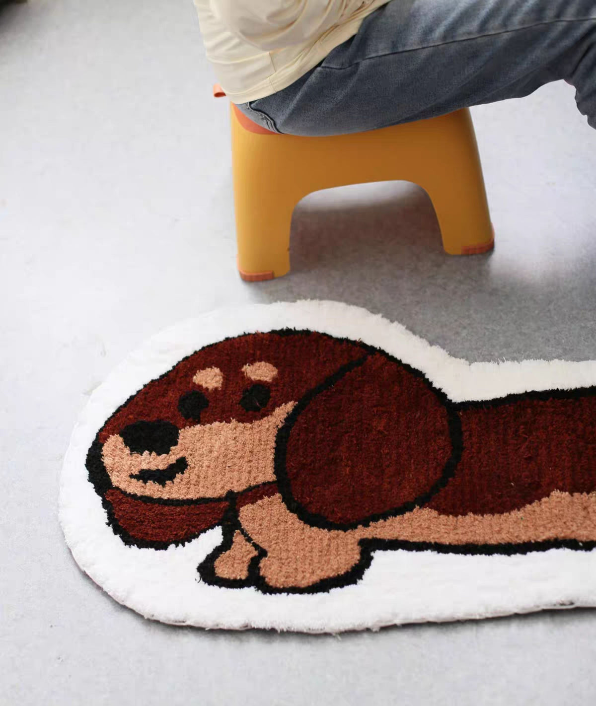 Dachshund rug head and body on a grey floor, plush acrylic pile with cream outline