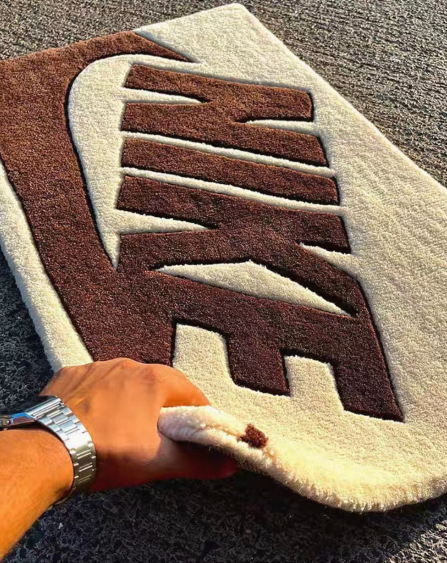 Brown cream swoosh tufted rug flat lay, sneakerhead clothing room decor rug, bold logo bedroom rug for streetwear and sneaker culture enthusiasts