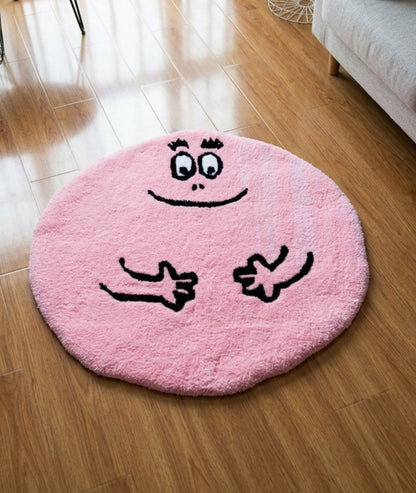 Barbapapa rug in pink with a smiling face, round tufted character mat styled on a wood bedroom floor