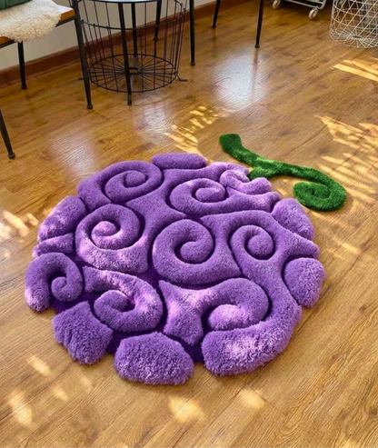 Purple swirl fruit rug with green stem on a wood floor, hand tufted anime bedroom decor, top view