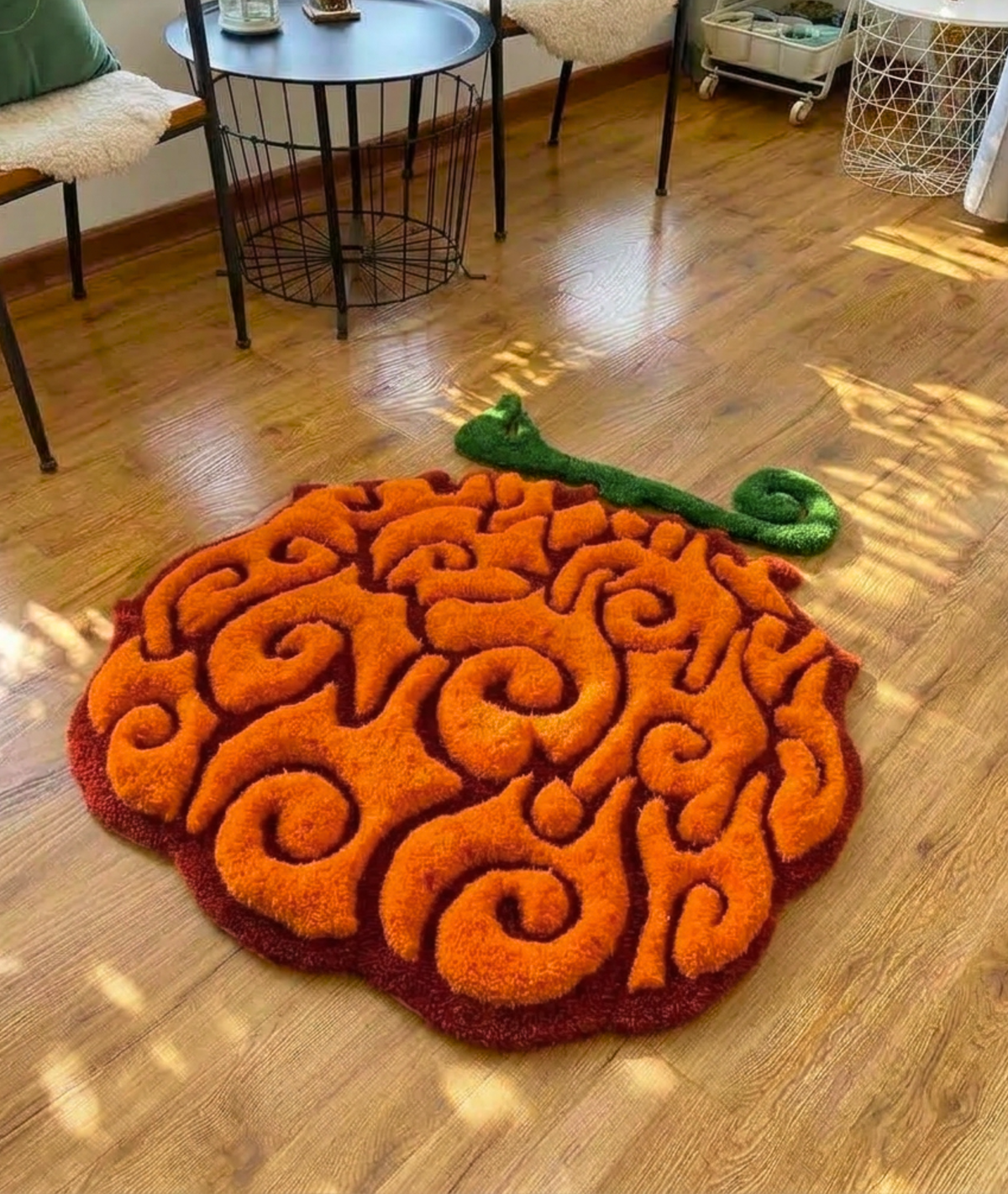 Orange swirl fruit rug with green stem on a wood floor, hand tufted anime bedroom decor, full top view