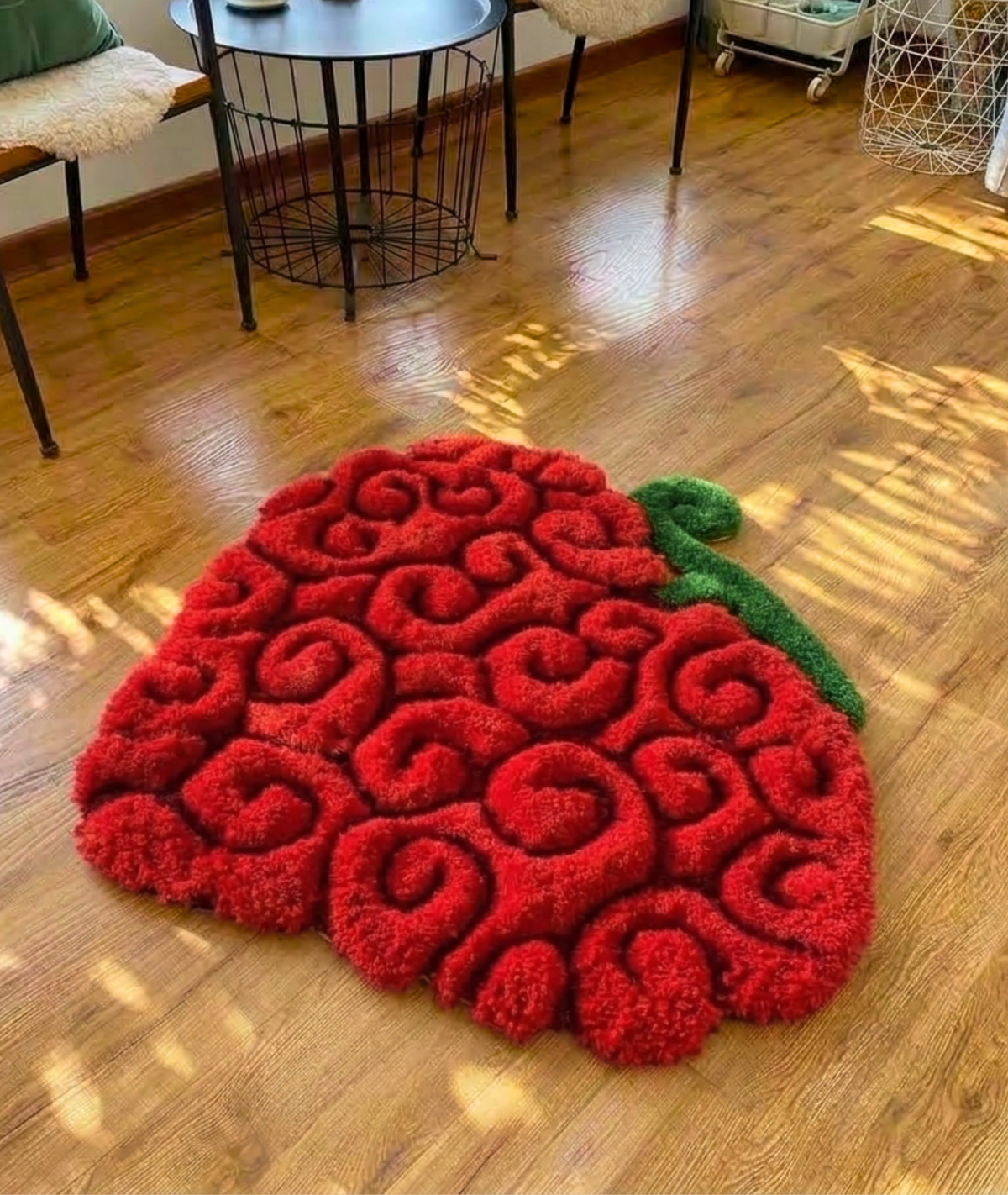 Red swirl fruit rug with green stem on a wood floor, hand tufted anime bedroom decor, top view