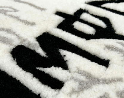White Monster Rug extreme close up of black lettering in thick high density tufted acrylic pile