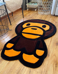 Hypebeast Baby Milo Bape Ape Head rug laying on floor. Hand-tufted orange brown black carpet in sneaker room. Streetwear bedroom gaming setup room decor.