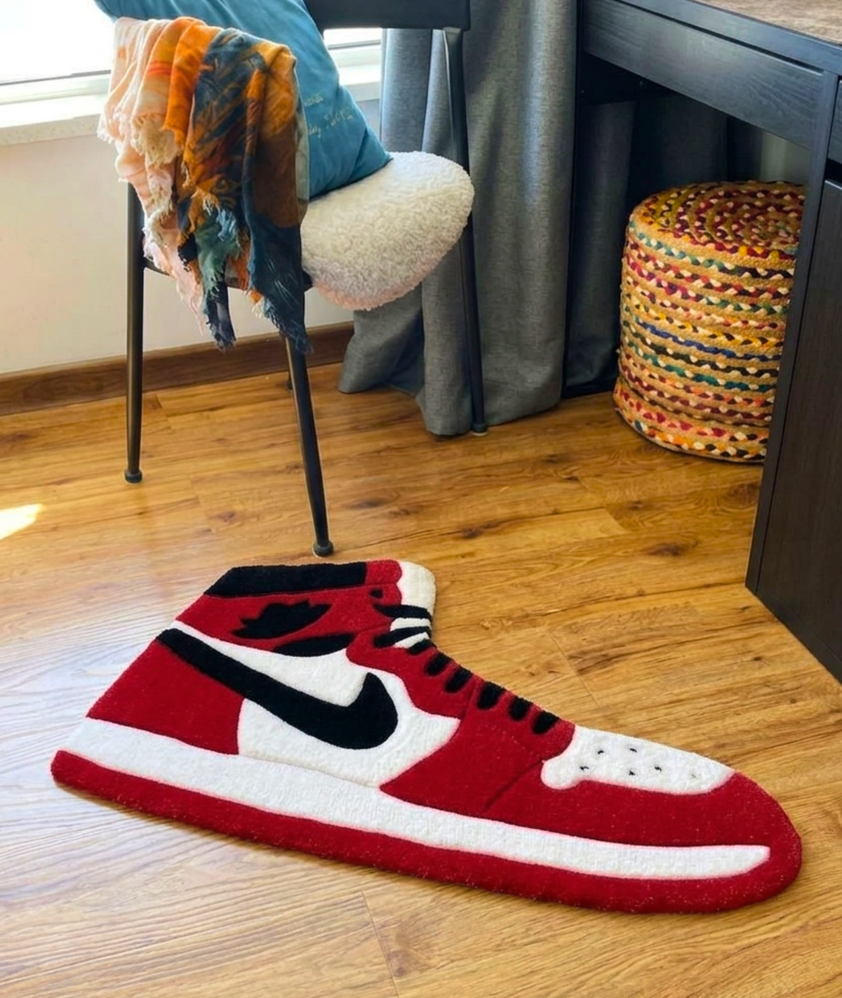 Sneaker rug beside a desk and chair, red and white tufted yarn floor decor, room setting