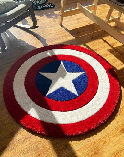 A round plush area rug featuring Captain America's shield design with red, white, and blue concentric circles and a white star in the center, shown on a wooden floor in a room setting.