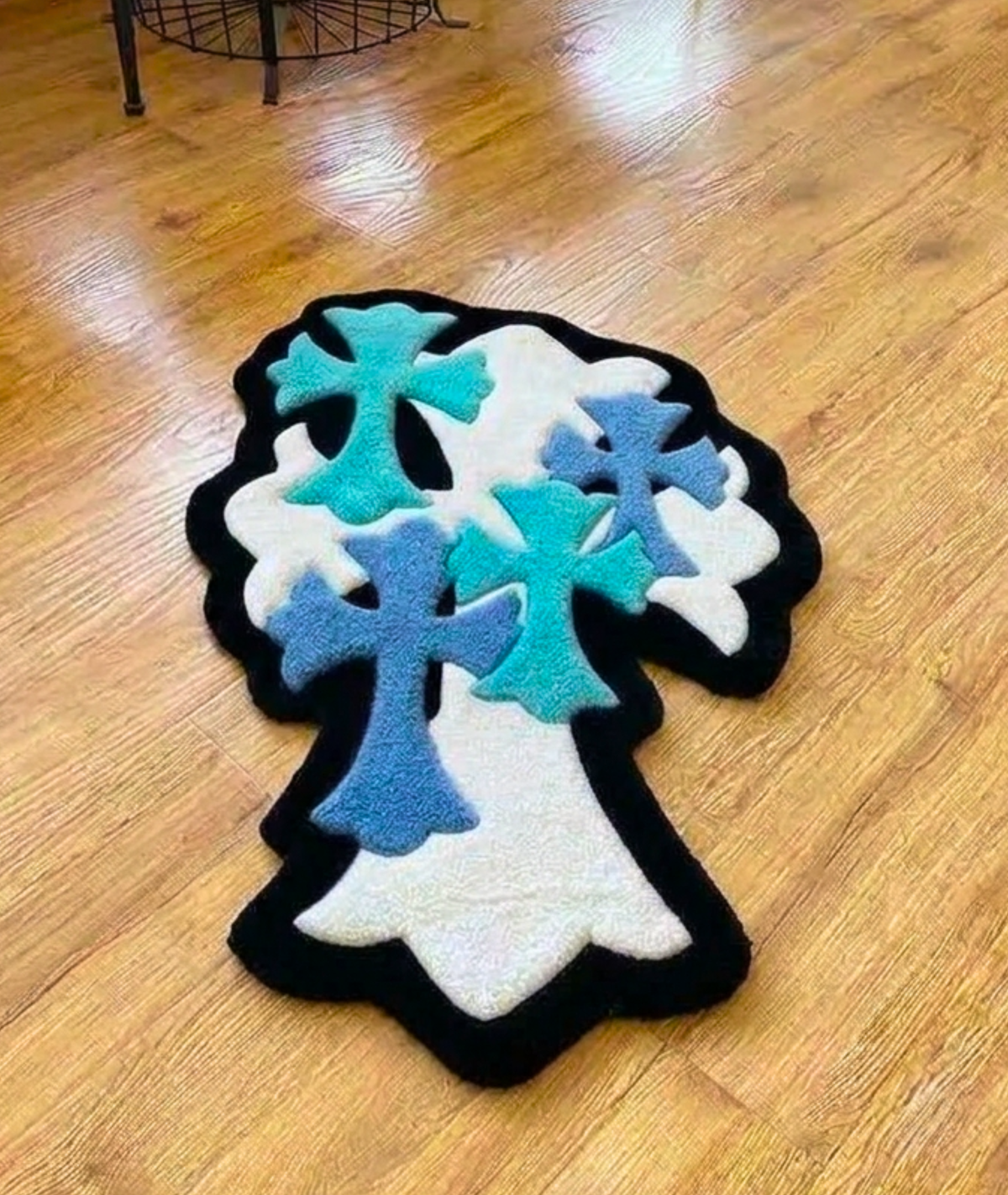 Blue and teal cross rug on a white base, dense tufted acrylic pile, top down floor view