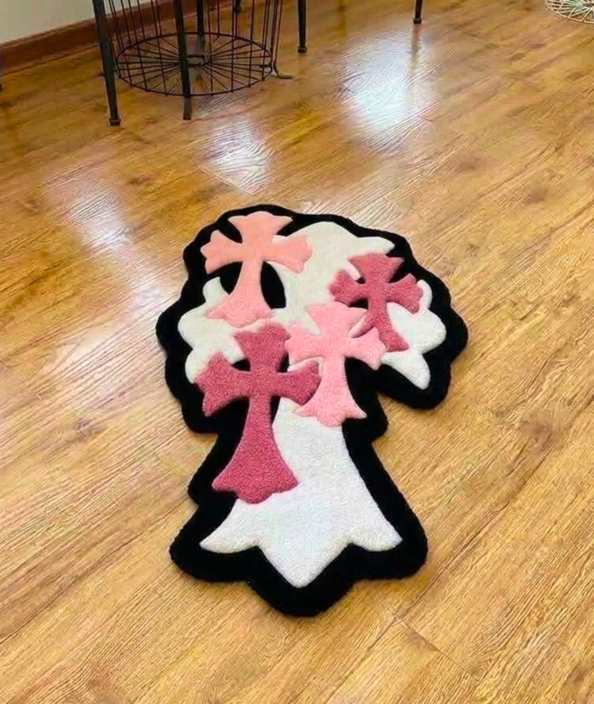 Pink cross cluster rug with black outline on hardwood, shaped alt room floor decor