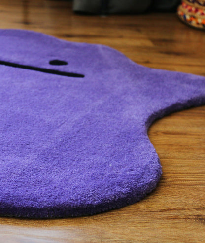 Shaped purple area rug edge on hardwood, plush acrylic yarn surface, low angle corner view