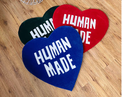 Hypebeast Human Made heart rug set green red blue laying on floor. Hand-tufted heart carpets in sneaker room. Streetwear bedroom gaming setup room decor collection.