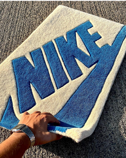 Blue swoosh tufted rug close up thick pile texture, sneaker inspired bedroom rug for hypebeast and streetwear collectors, shoe shelf display rug