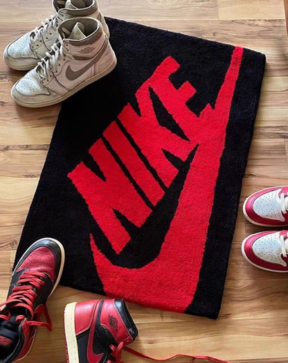 Red swoosh tufted rug styled in sneakerhead bedroom with sneakers placed on top, hypebeast room decor rug for clothing room or shoe display setup