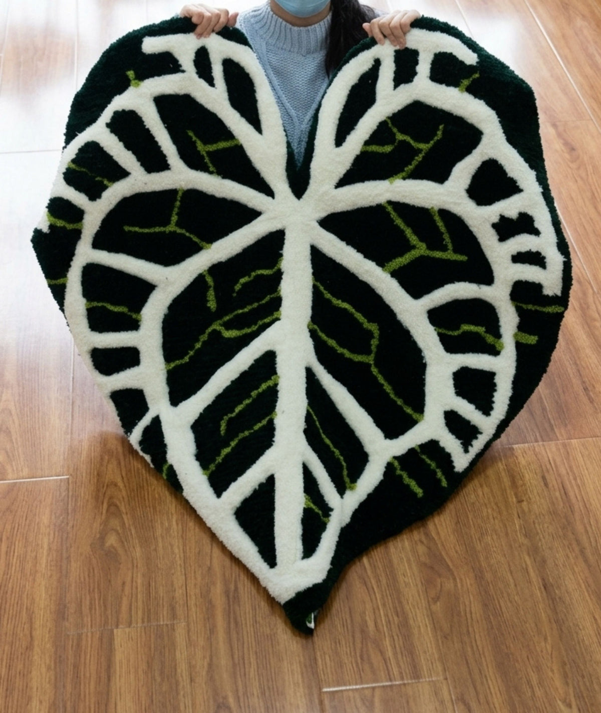 Large leaf rug held open to show its full outline, black white and lime tufted yarn