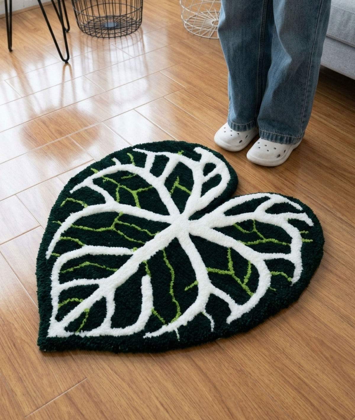 Leaf shaped area rug with white and green veins on dark green, living room floor view