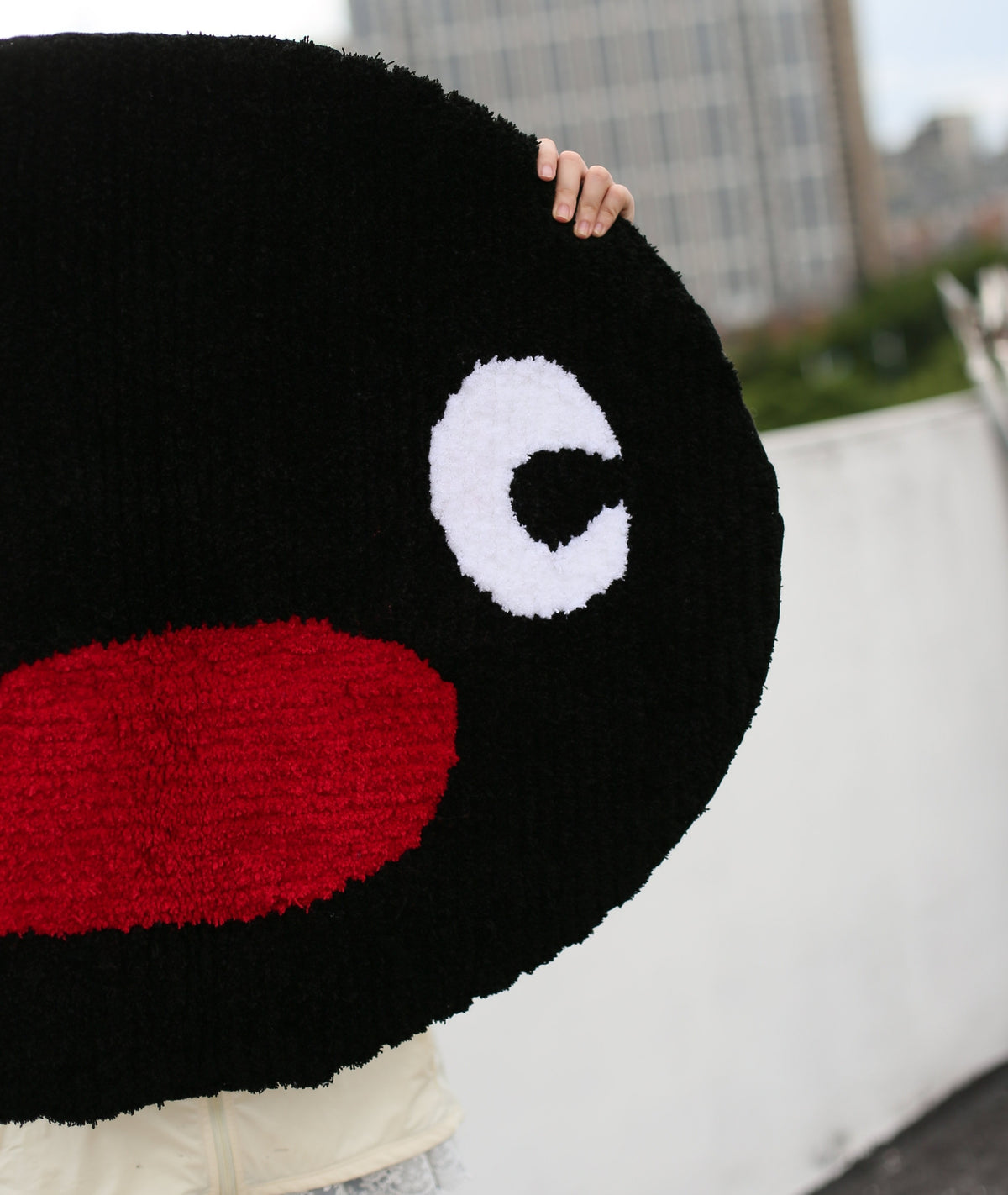 Close-up of the Pingu rug texture, showing tufted black fur, red beak, and white eye detail