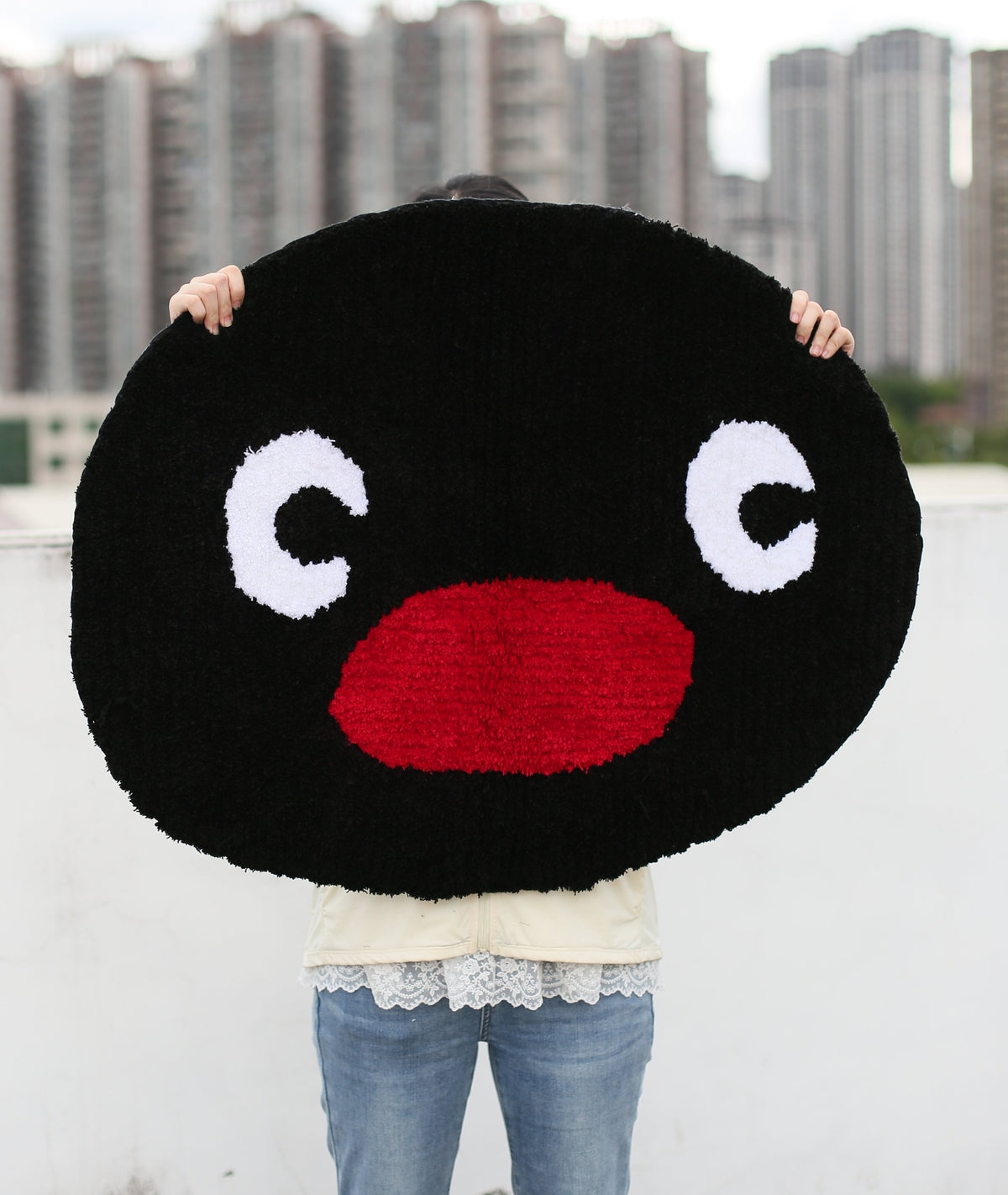 Pingu character rug held up to show the face and big eyes, soft high-density acrylic yarn tufting