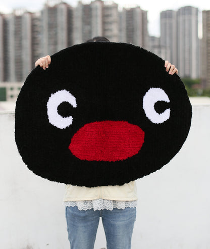 Pingu character rug held up to show the face and big eyes, soft high-density acrylic yarn tufting