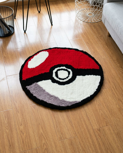 A round plush rug designed like a Pokéball, featuring red, white, black, and gray colors, placed on a light brown wooden floor in a modern living room setting.