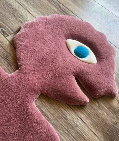 Close up of the pink rug head, raised cream and blue eye over soft tufted pile, texture detail