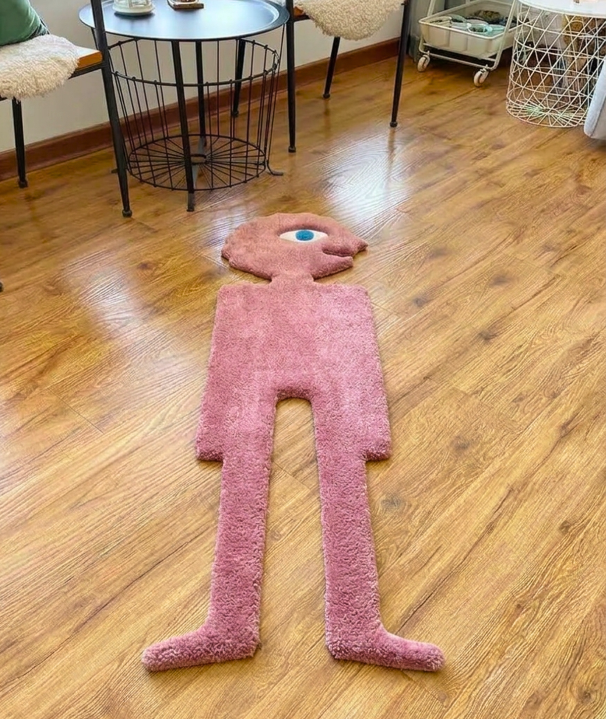 Shaped pink character rug on a wood floor, soft acrylic tufted pile, living room top down view