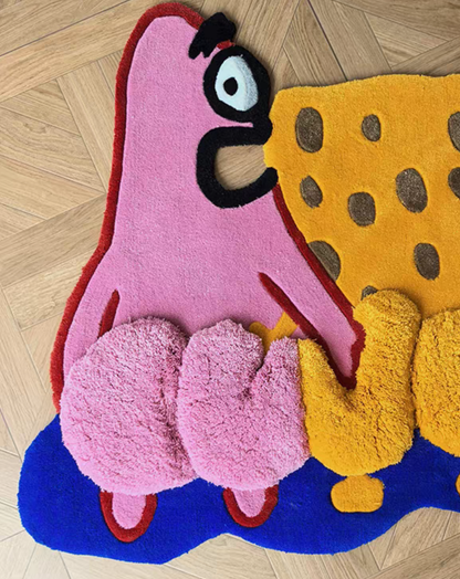 A colorful, plush, hand-tufted rug shaped like Patrick Star and SpongeBob SquarePants, displayed on a light-colored wooden parquet floor.