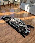 Sports Car Rug hand tufted silver and black car shaped rug with rear wing, top view on a wooden floor