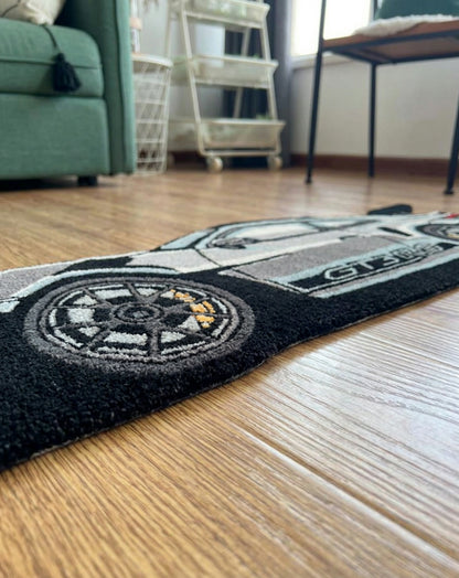 Gaming room car rug low angle close up of the tufted wheel with gold brake detail and black border