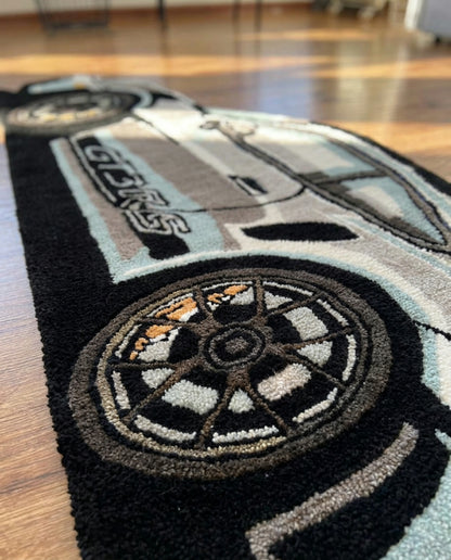 Hand tufted sports car rug close up of side stripes, wheel and thick acrylic pile on a hardwood floor