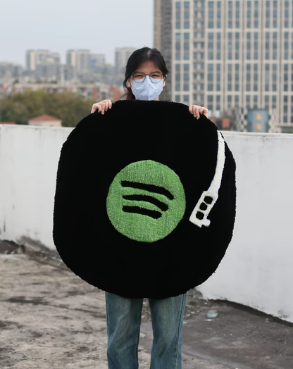 Round Spotify music rug held up to show the green logo and vinyl design, soft high-density acrylic yarn