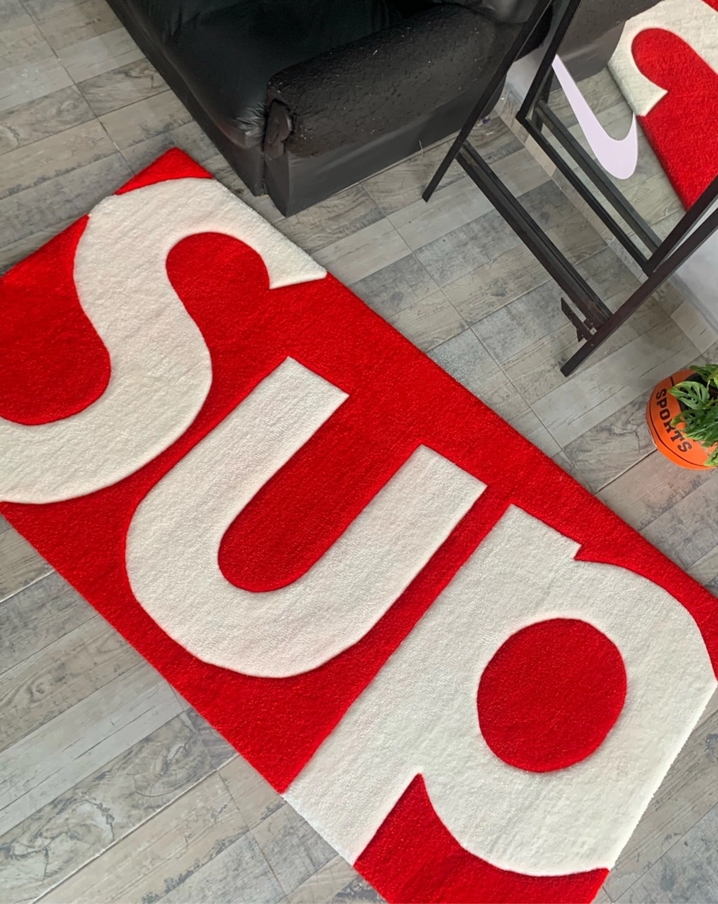 Hypebeast Supreme white blue box logo rug laying on floor. Hand-tufted white blue runner carpet in sneaker room. Streetwear bedroom gaming setup room decor.