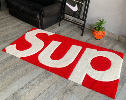 Supreme inspired red white tufted runner rug in hype room. Hand-tufted box logo carpet for sneaker collection display. Streetwear home decor gift for sneakerhead.